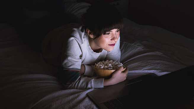 woman watching movie with popcorn